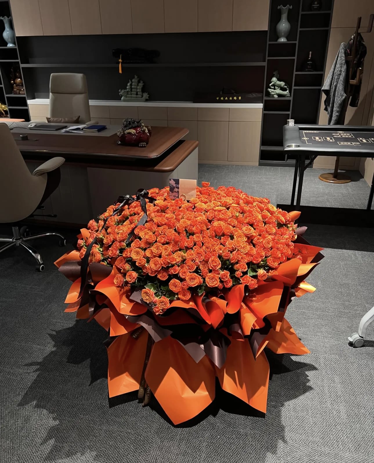 Large bouquet of orange roses wrapped in bright orange paper