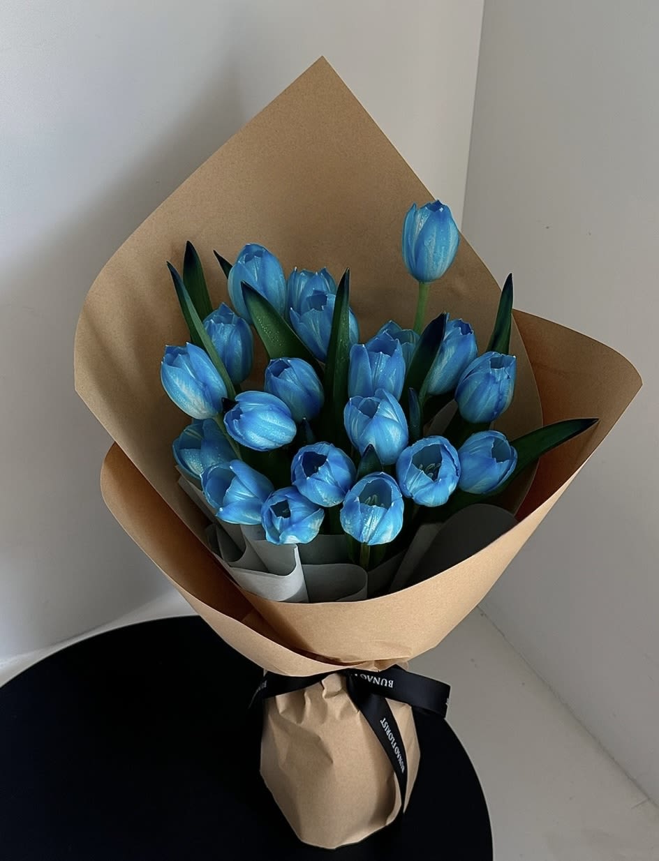 Bouquet of bright blue tulips wrapped in brown paper
