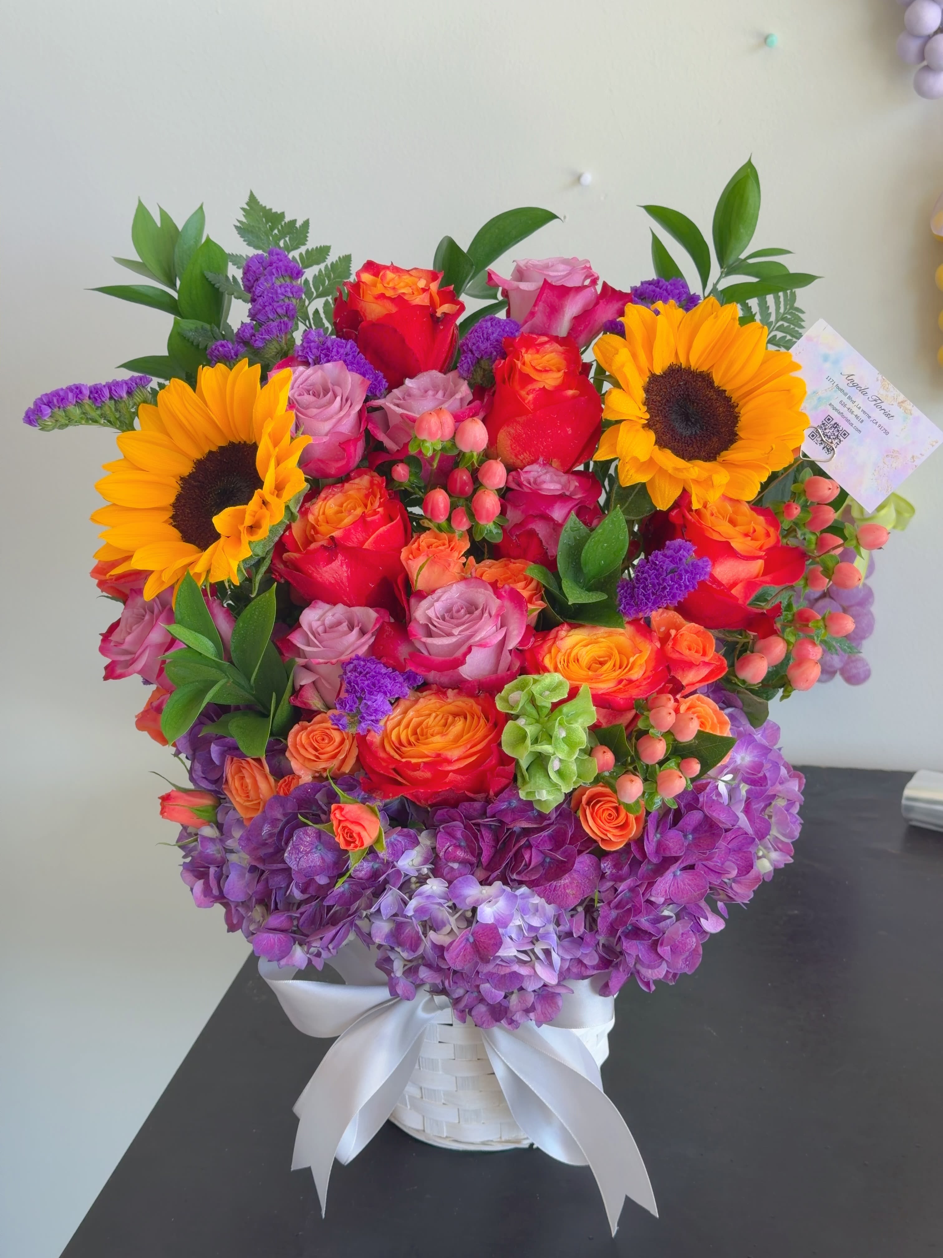 Luxury Sunset Garden - Perfect For * Funeral / Celebration of Life * Birthday * Grand Opening * Luxury Gifting  Product Description A luxurious floral arrangement inspired by glowing sunset skies and lush garden romance. Featuring radiant sunflowers, premium sunset roses, lavender blooms, and rich hydrangeas, this design brings warmth, elegance, and heartfelt beauty to any meaningful occasion.