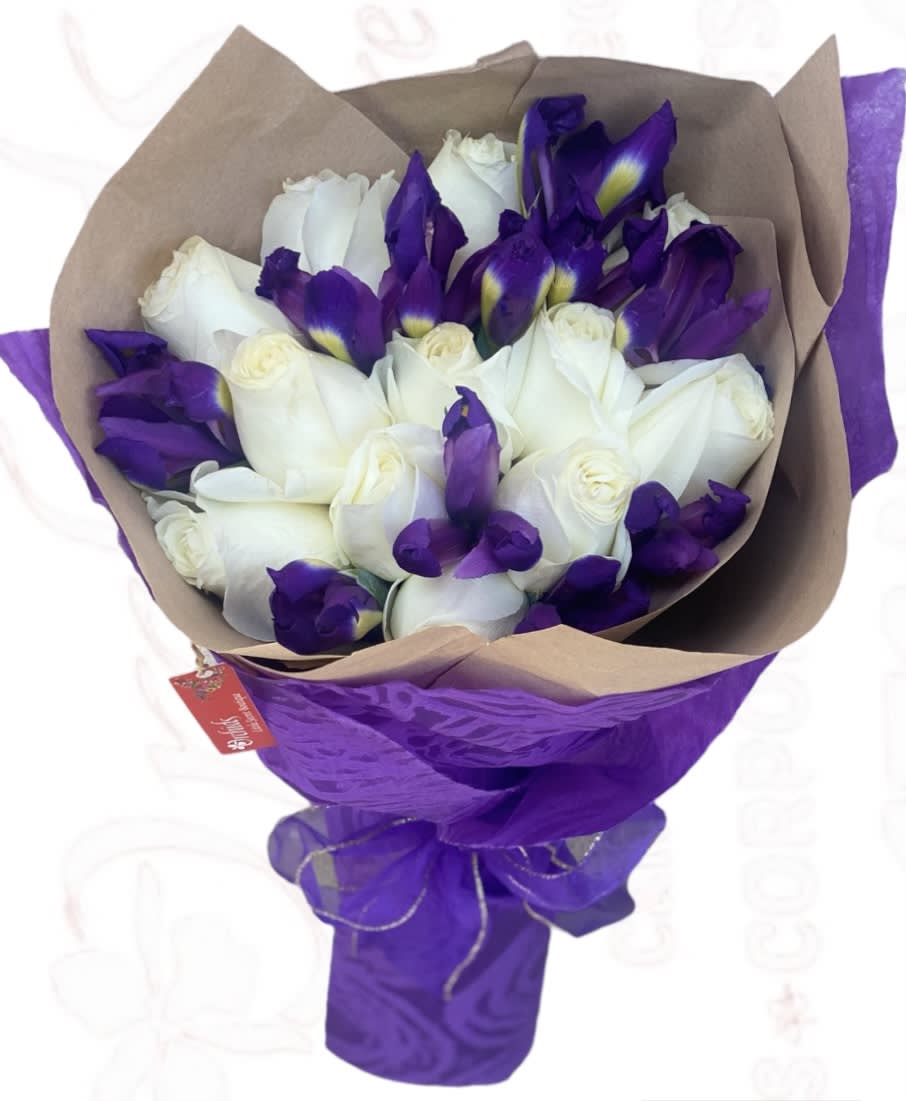 Bouquet of white roses and purple irises wrapped in brown and purple paper