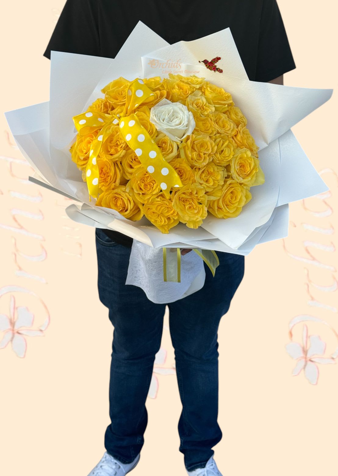 Bouquet of yellow roses wrapped in white paper with a polka-dot ribbon