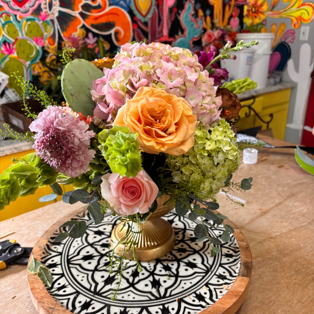 Mixed bouquet in a gold vase with pink and peach blooms
