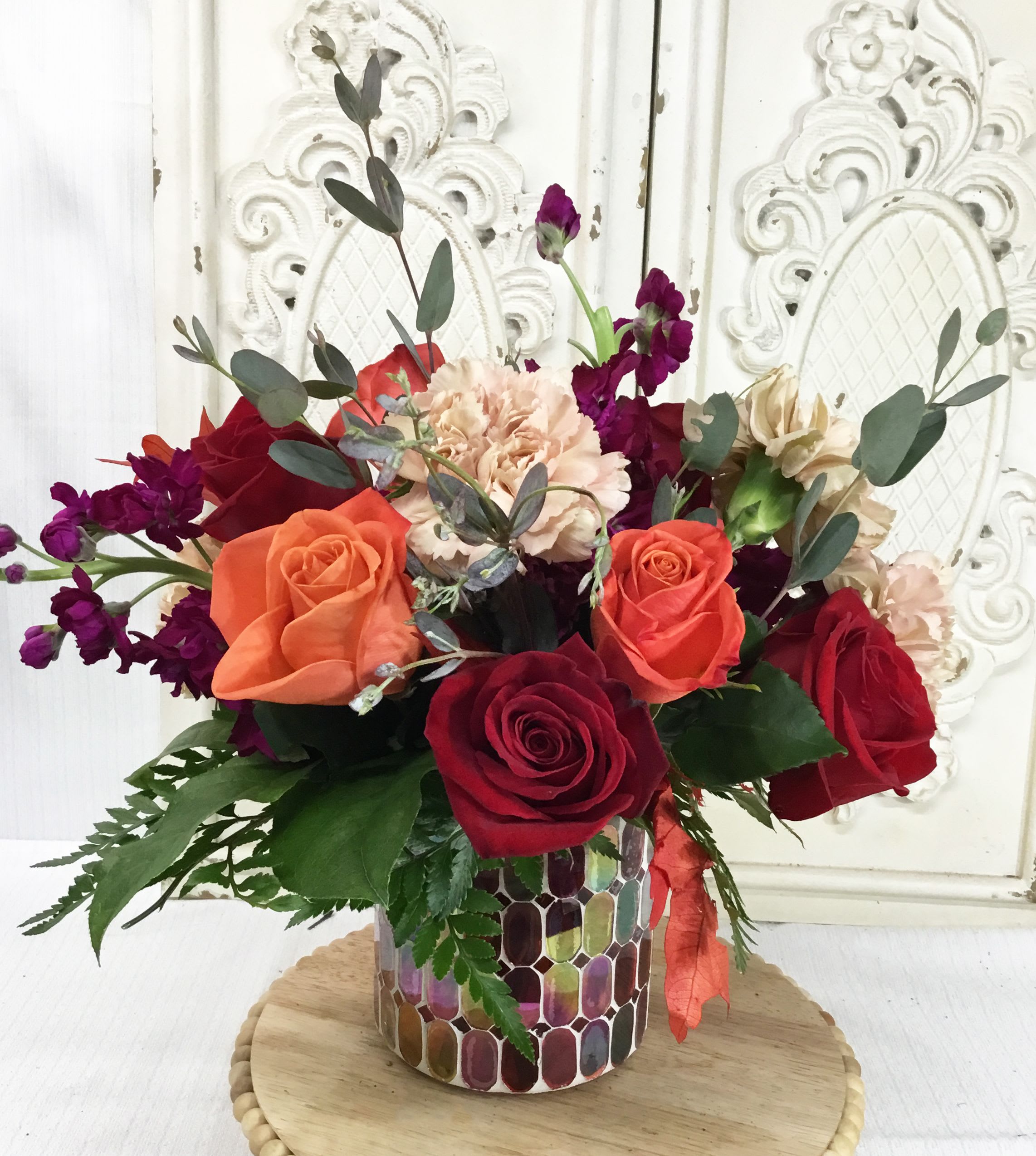 Mixed bouquet of roses and carnations in a mosaic vase