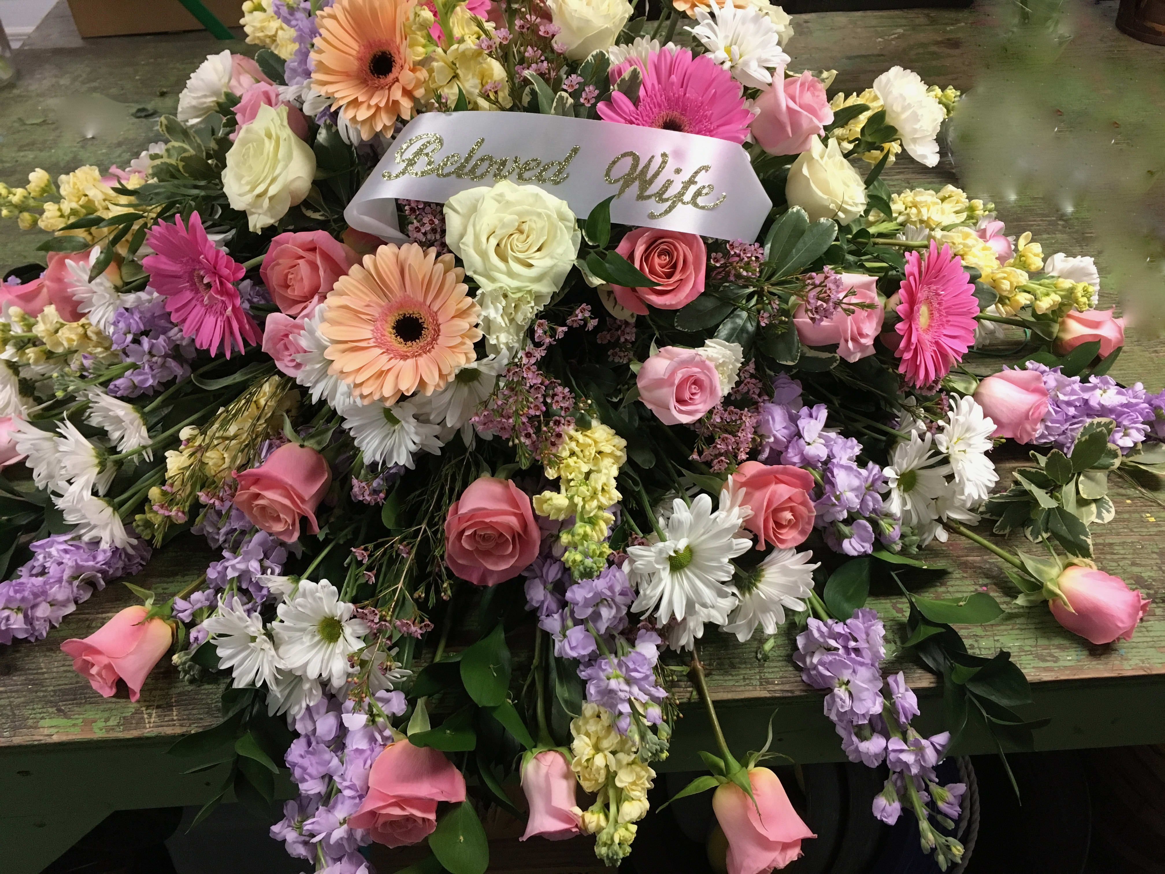 Large pink, white, and lavender floral spray with a "Beloved Wife" ribbon