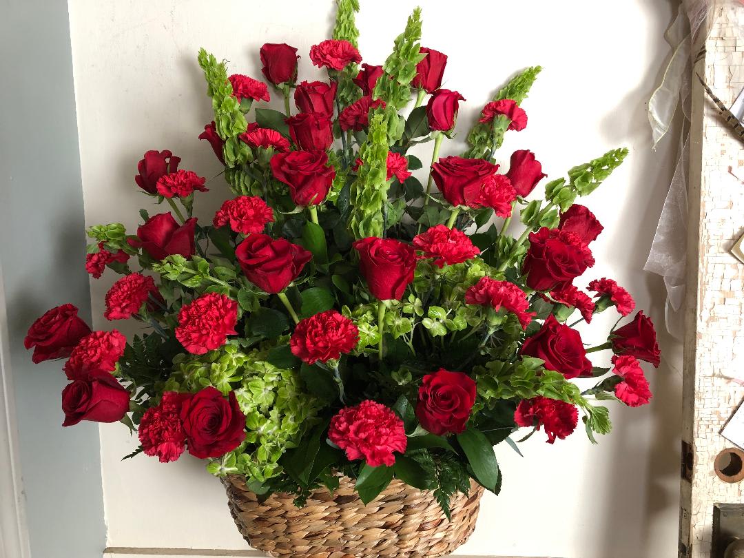 Basket arrangement of red roses and carnations