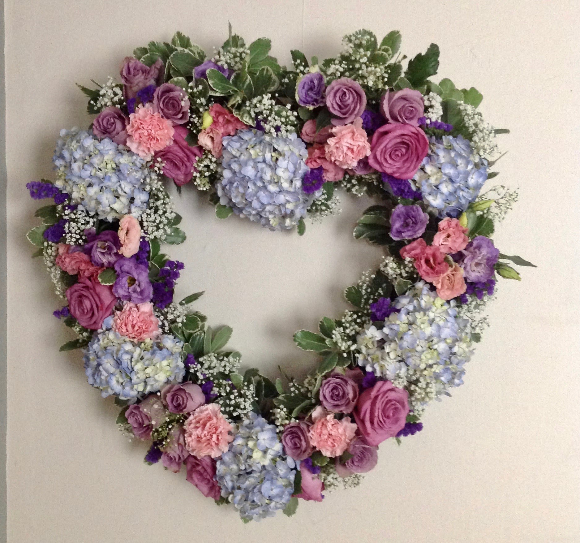 Heart-shaped floral wreath with pink, purple, and blue flowers