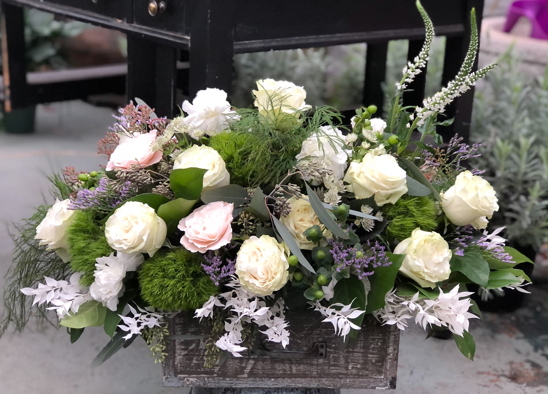 Mixed white and blush roses arranged in a rustic wooden box