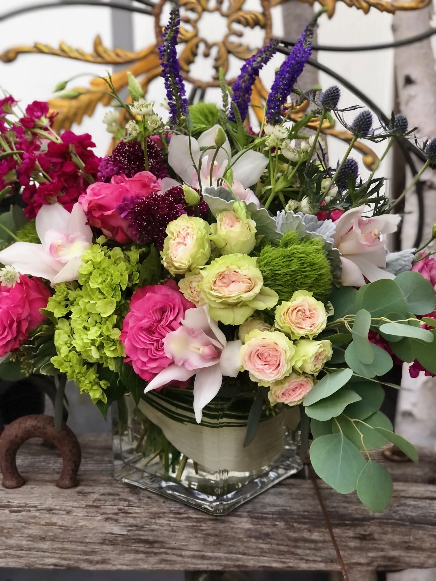 Mixed bouquet in a glass vase with pink, white, green, and purple flowers