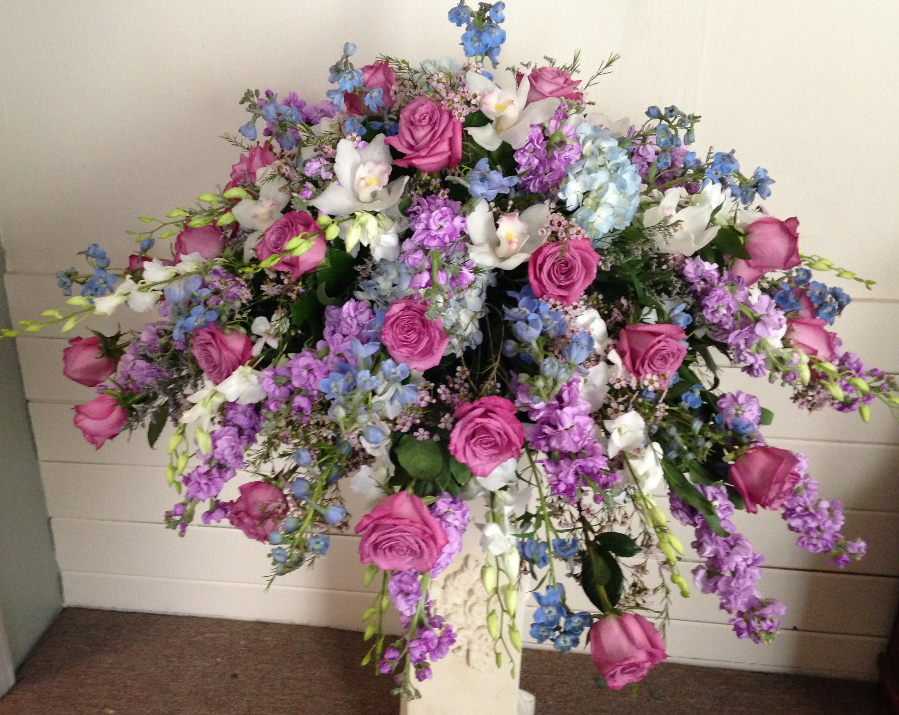 Large bouquet of pink roses, white orchids, and blue flowers