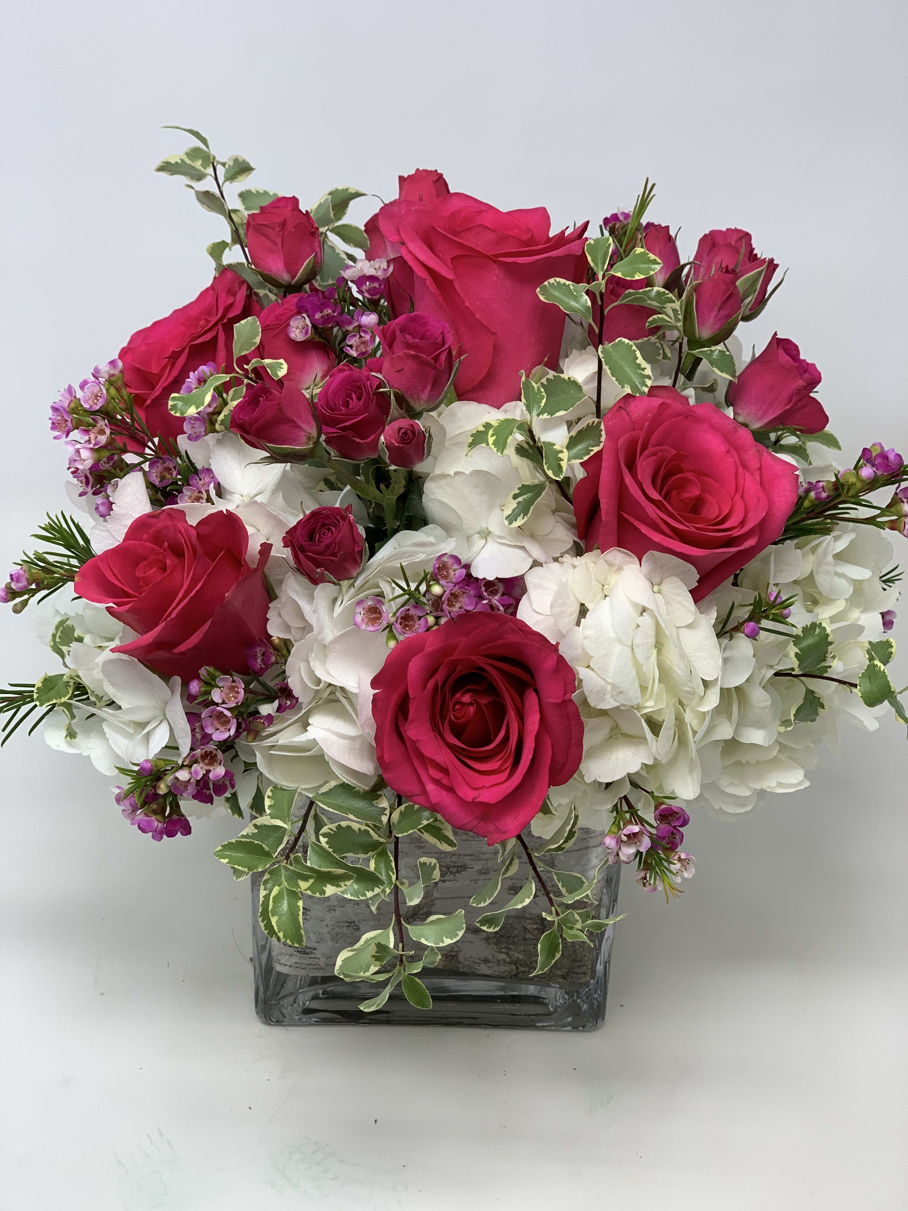 Pink roses and white hydrangeas in a square glass vase