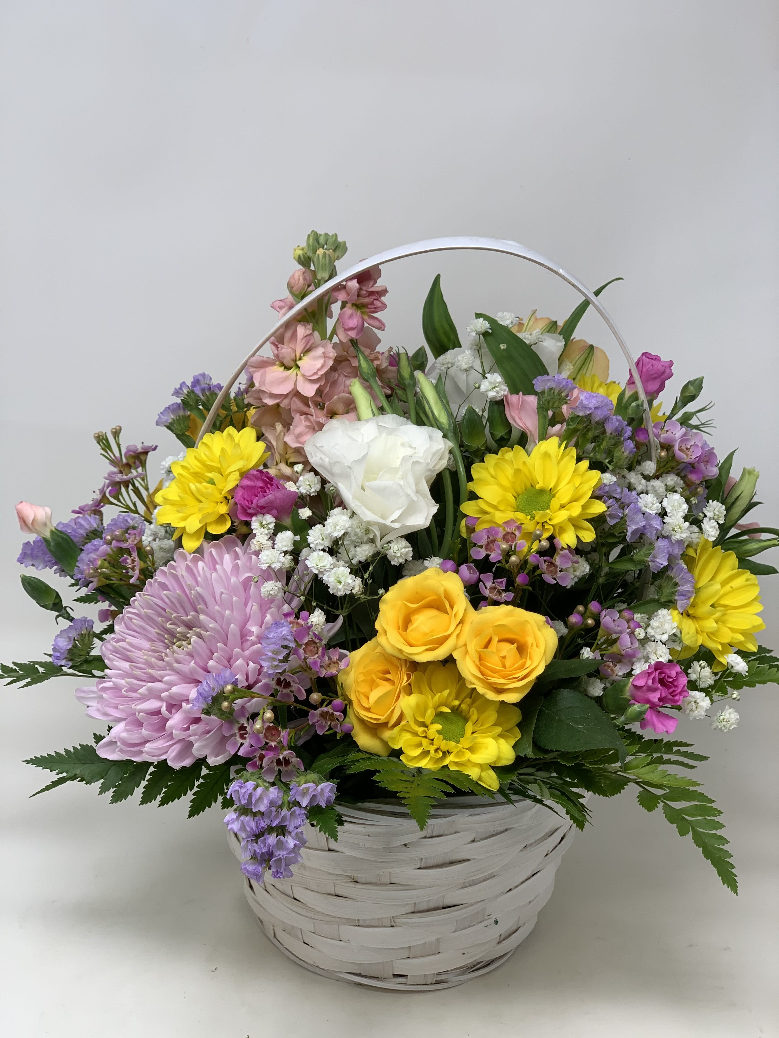 Mixed flower basket with yellow, pink, purple, and white blooms