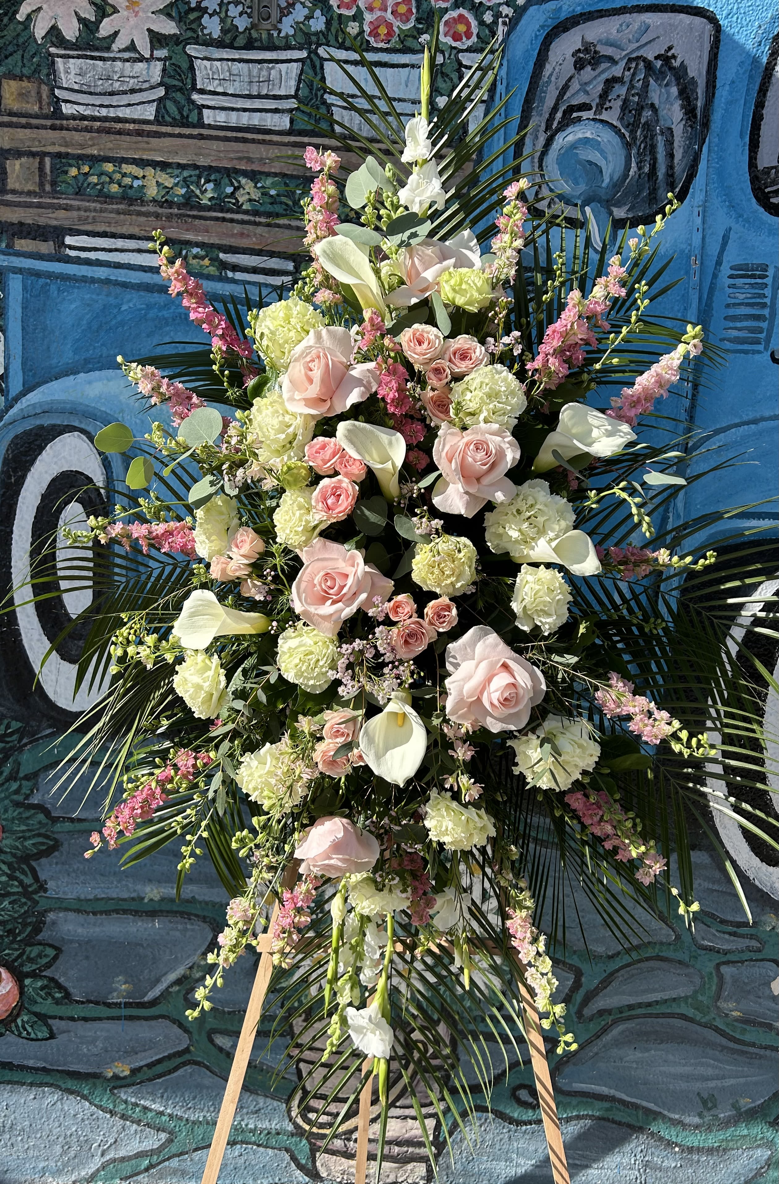 Tall floral spray with pale pink roses, white calla lilies, and pink accents