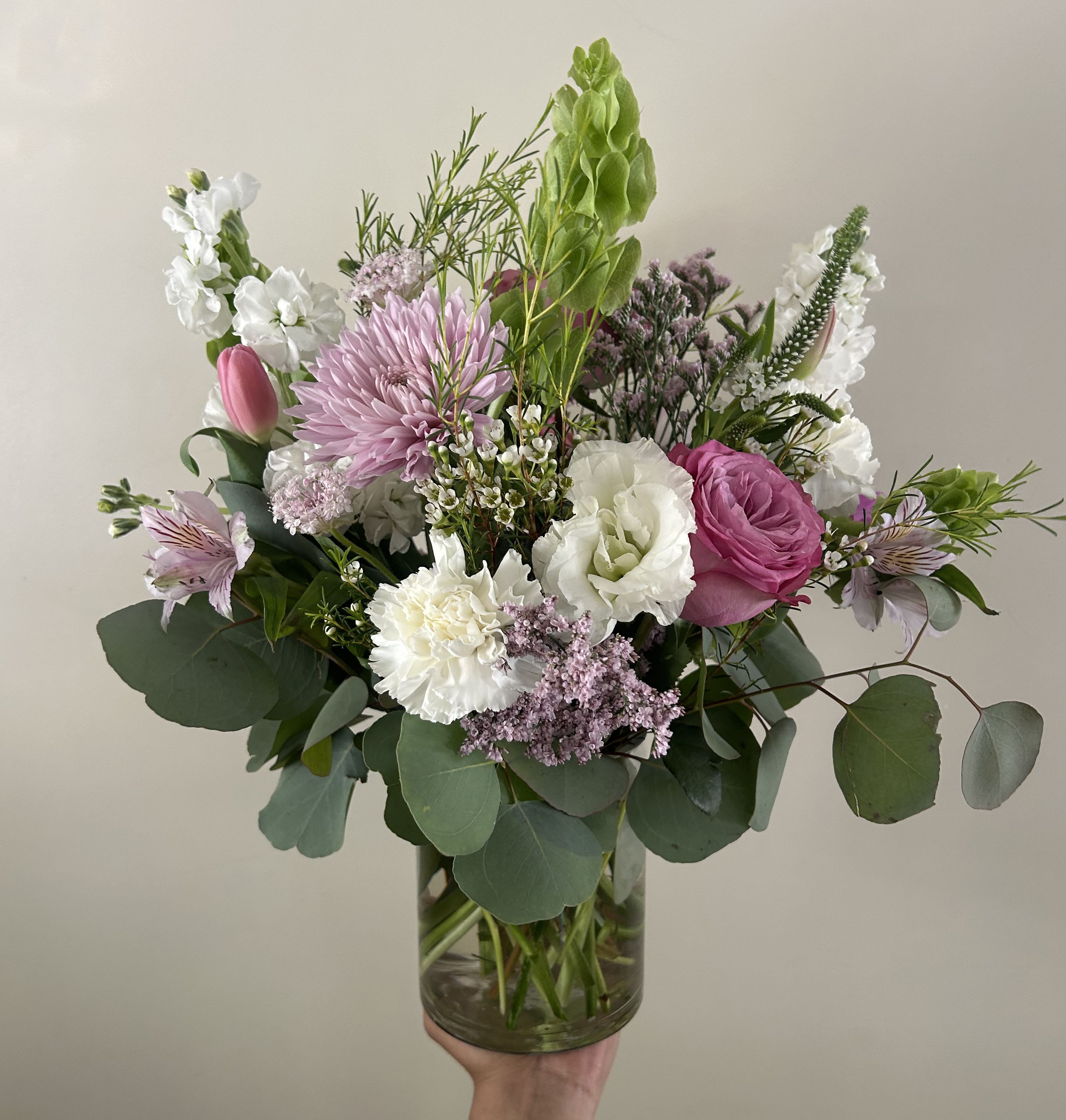 Pink Mauve - Seasonal light pink, lavender, and white flowers arranged into a vase with fillers and greens.