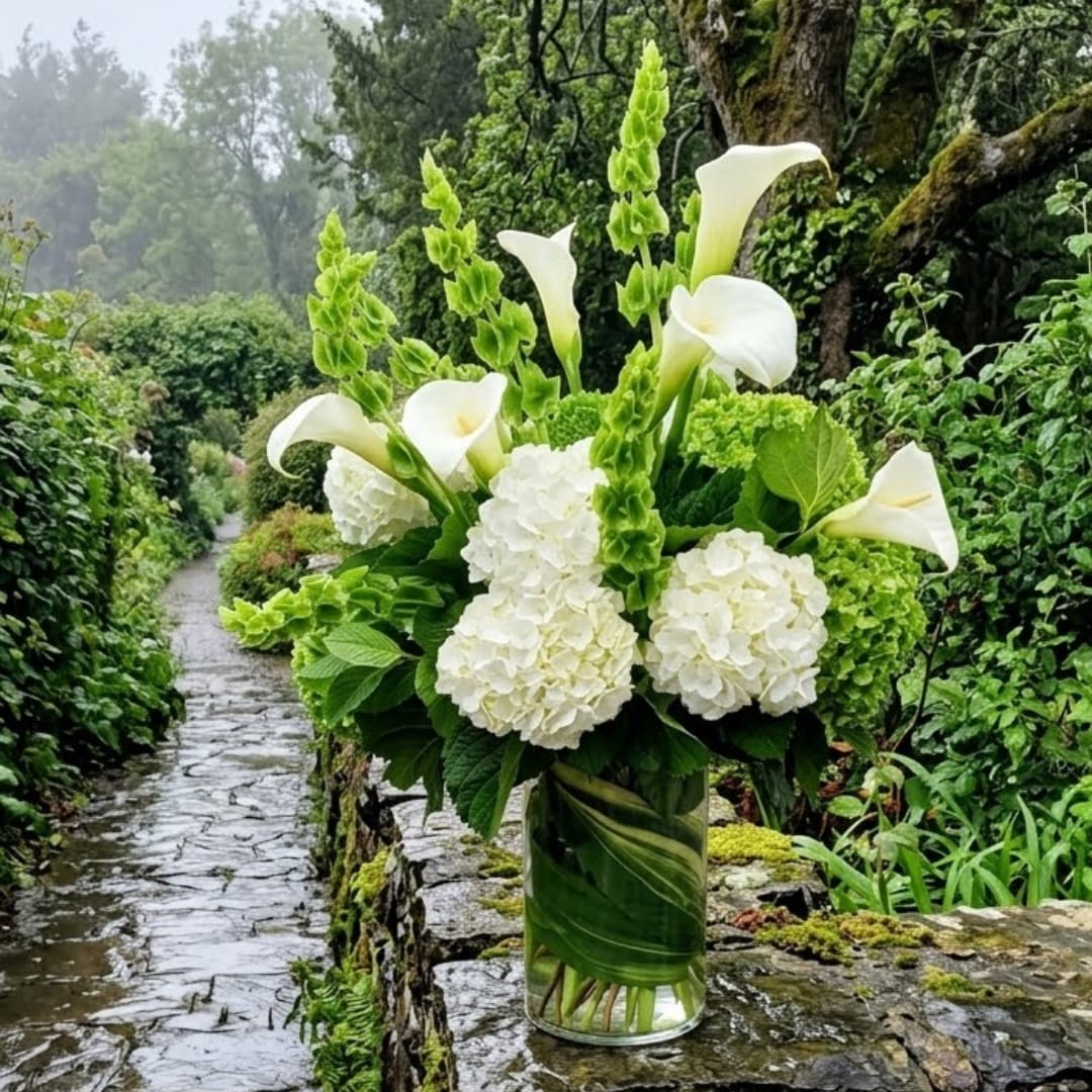 White calla lilies and hydrangeas in a glass vase