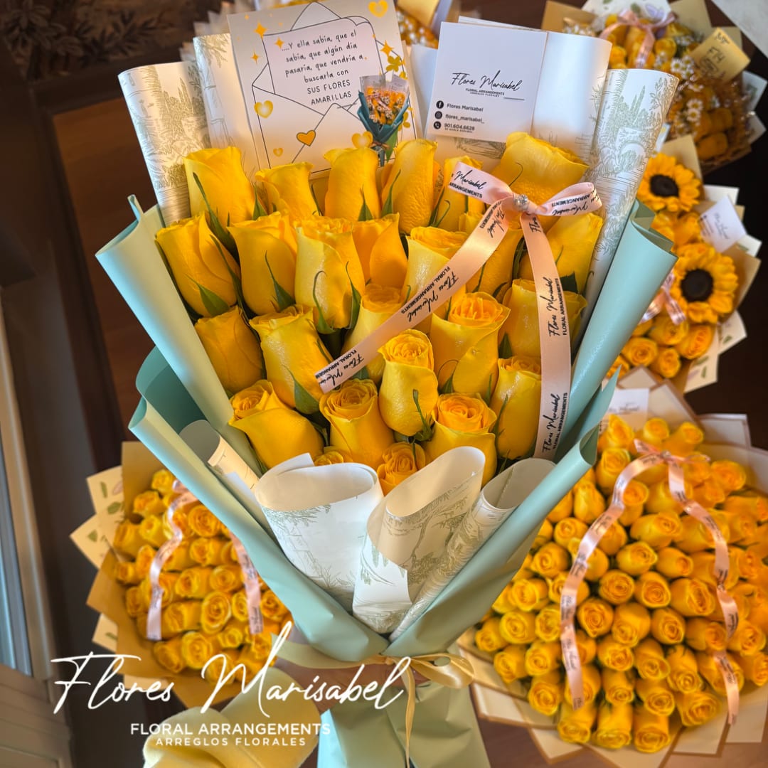 Bouquet of yellow roses wrapped in pale blue paper with a ribbon