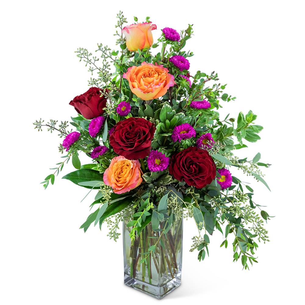 Mixed bouquet of red and orange roses in a clear glass vase