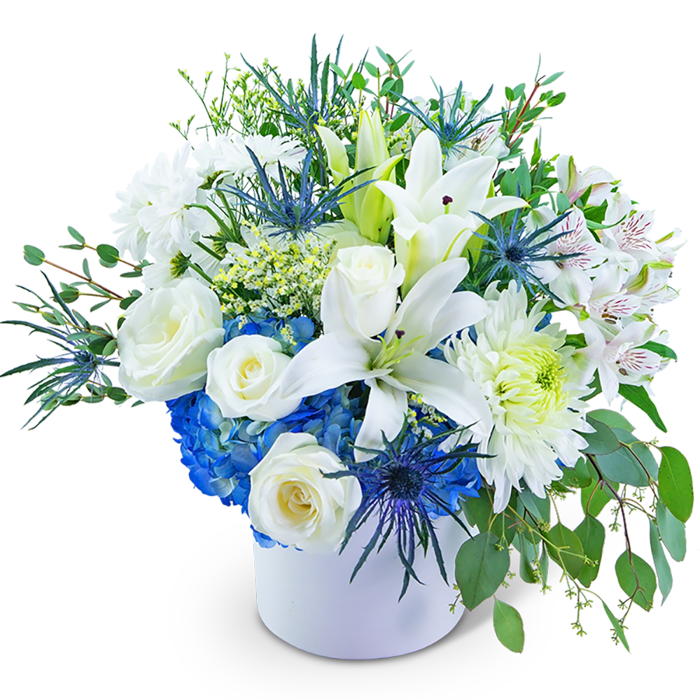 White lilies and roses in a white vase with blue hydrangea accents