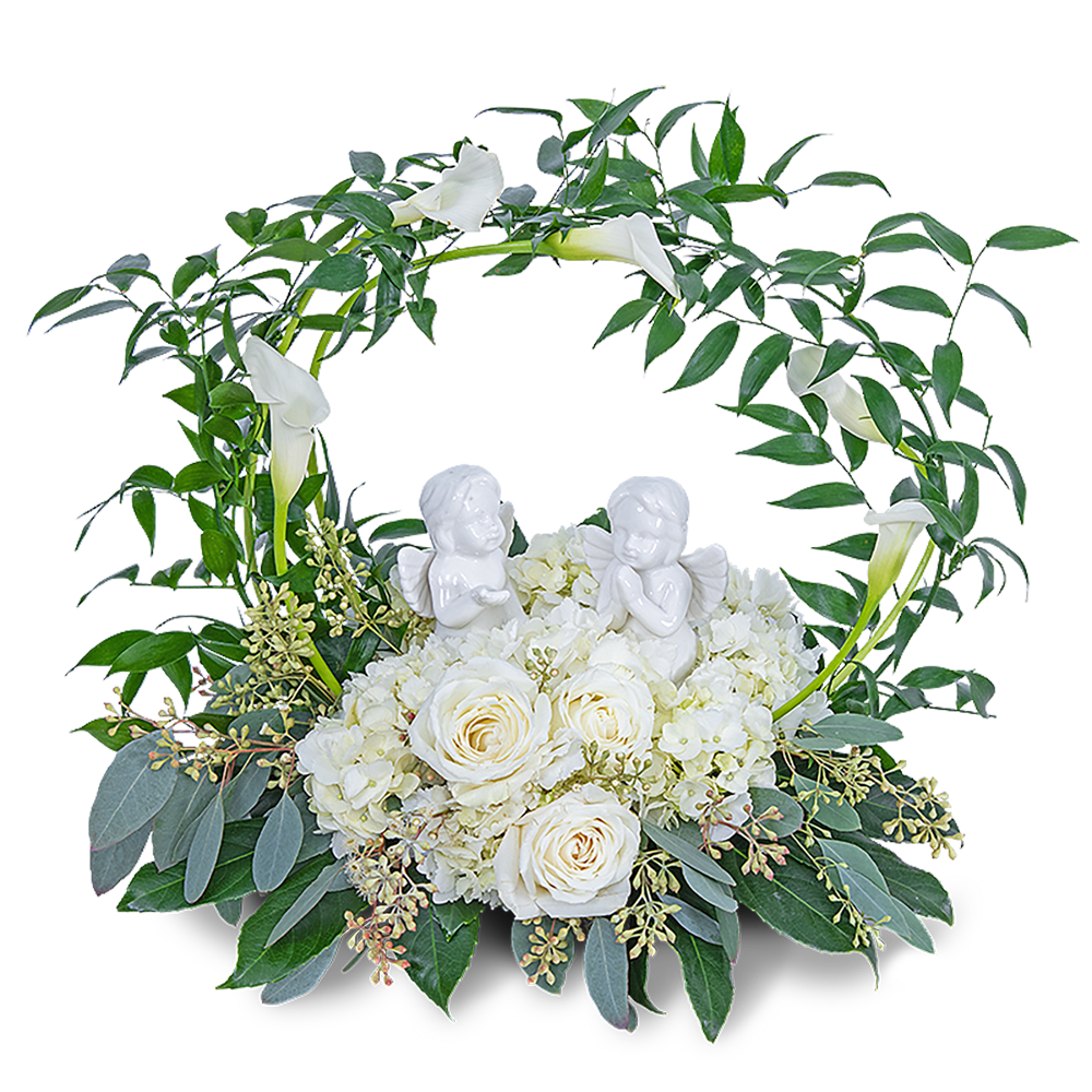 White roses and calla lilies in a circular floral wreath with angel figurines