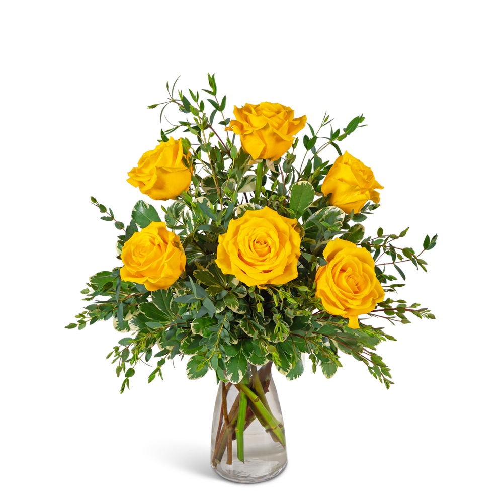 Yellow roses in a clear glass vase with mixed greenery