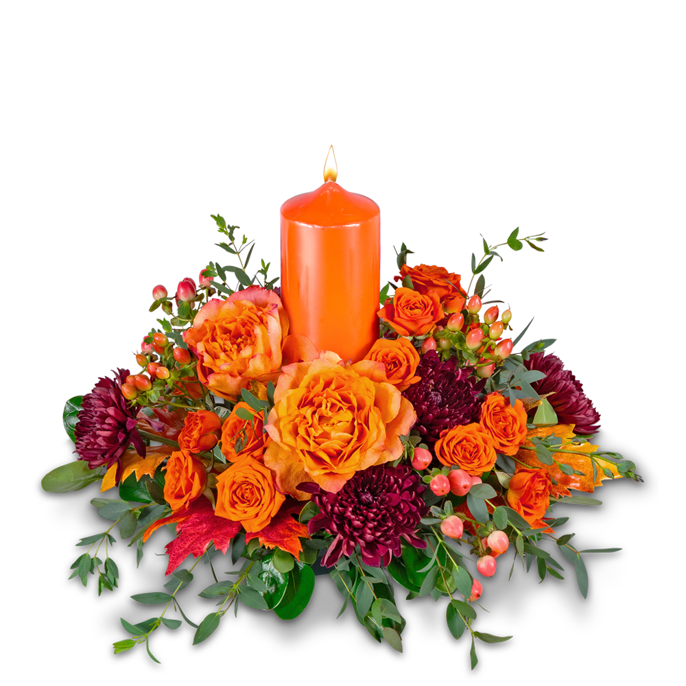 Orange candle surrounded by orange and burgundy flowers