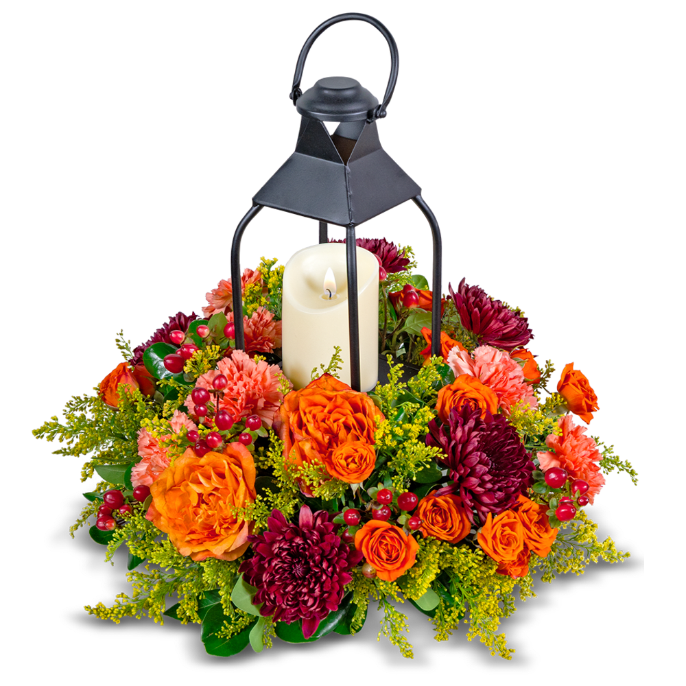 Lantern with a candle surrounded by orange and burgundy flowers