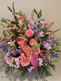 Pink and lavender floral arrangement with a pink ribbon