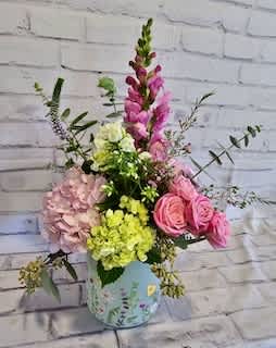 Pink and yellow mixed flower arrangement in a painted vase