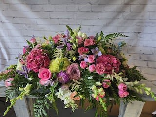 Large pink and purple floral arrangement in a container