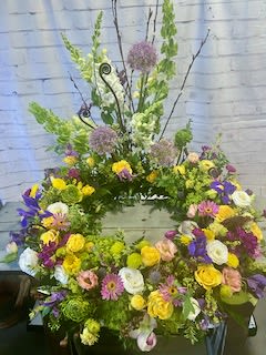 Large wreath of mixed flowers in yellow, purple, white, and pink