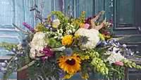 Mixed bouquet with sunflowers and white blooms in a container