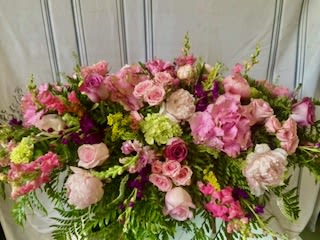 Large pink and white floral arrangement with roses and mixed blooms