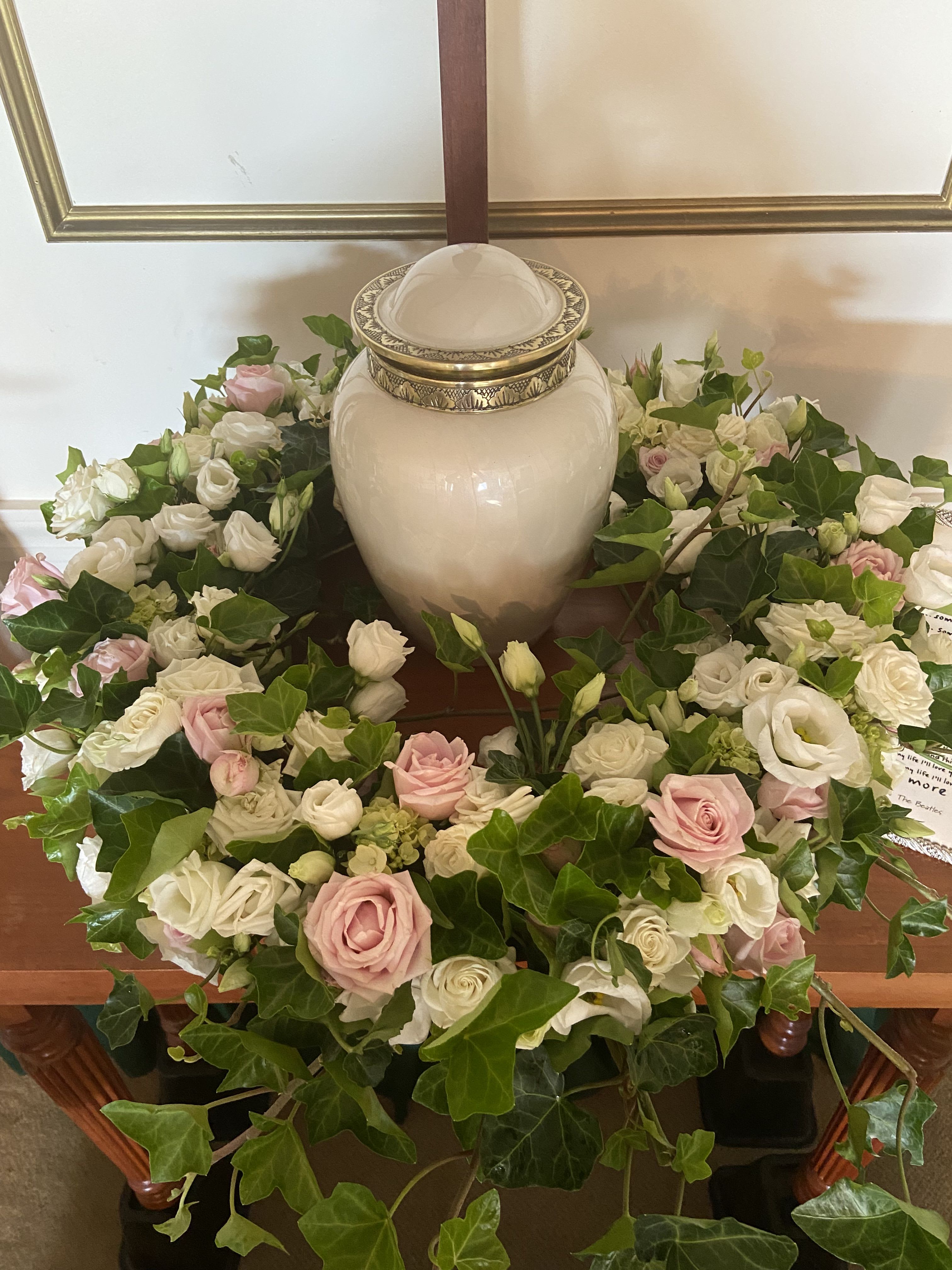 White and pink rose wreath around a ceramic urn