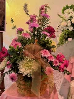 Basket arrangement of pink and white flowers with a ribbon
