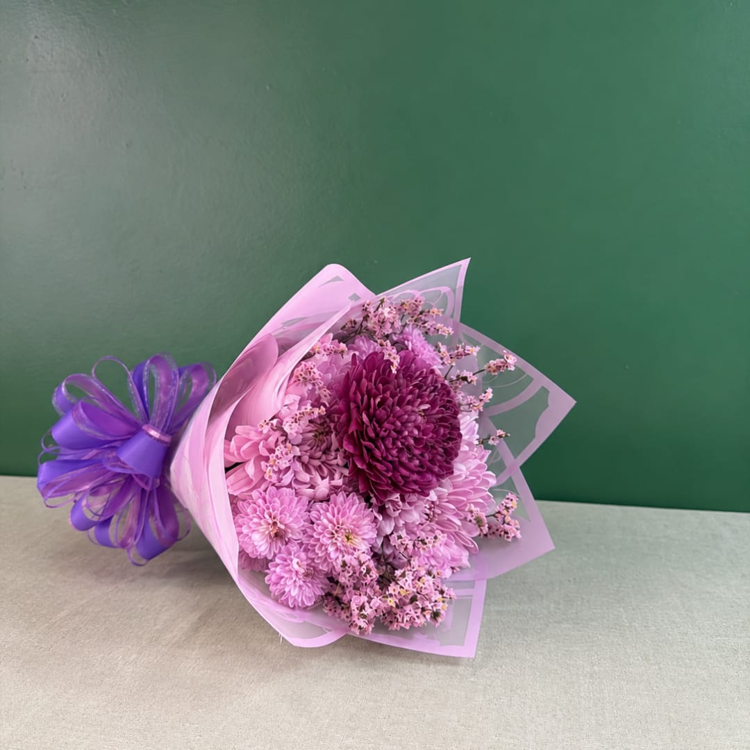 Pink and purple chrysanthemum bouquet wrapped in translucent paper