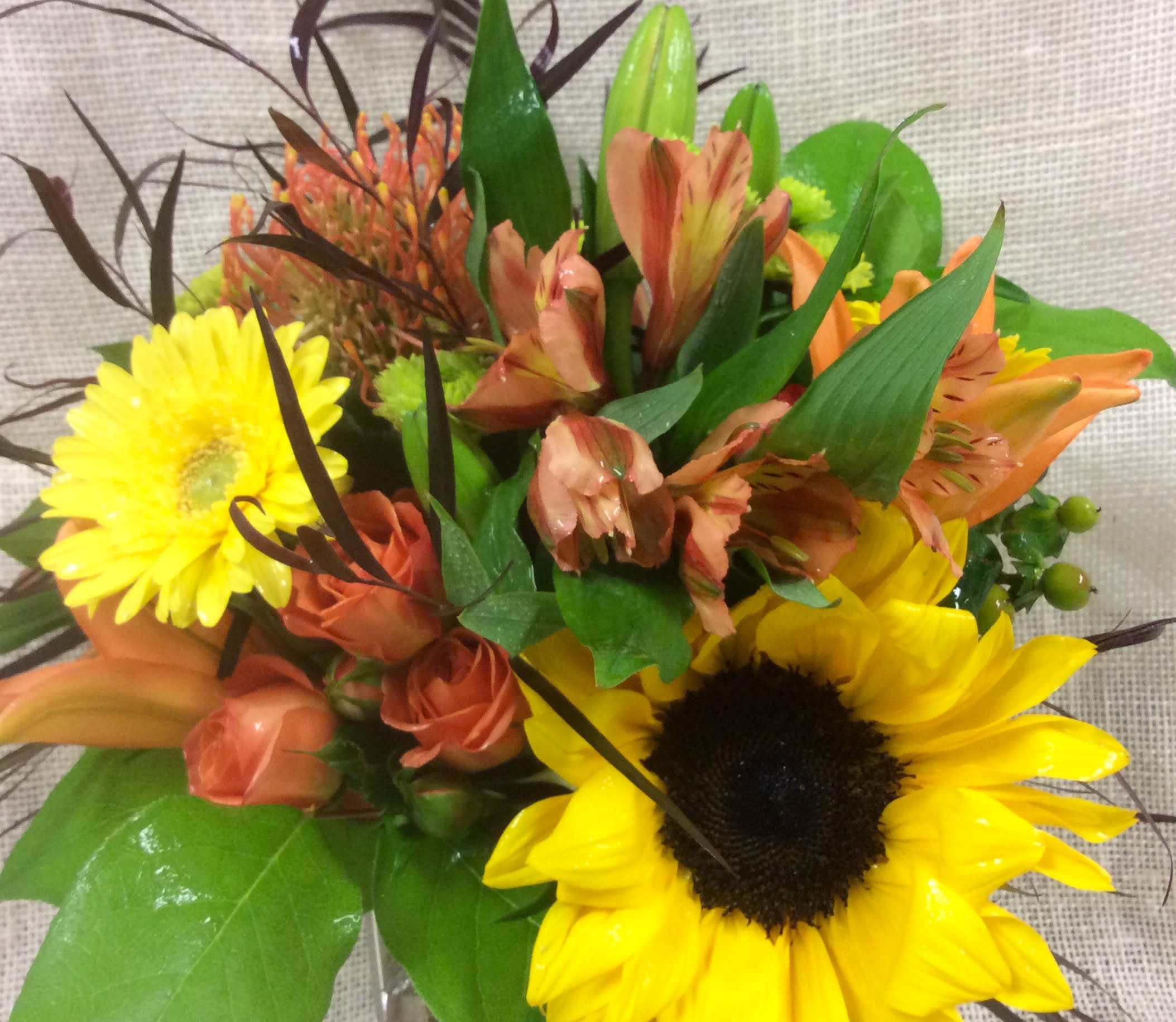 September Sunset - The colors and textures of fall inspire this robust arrangement, with a distinctive juxtaposition of delicate blooms and hearty, woodsy elements.  We custom create each design, based on flower availability and want each arrangement to be one of a kind.  Be assured- your arrangement will have the look and feel of the arrangement you've chosen.