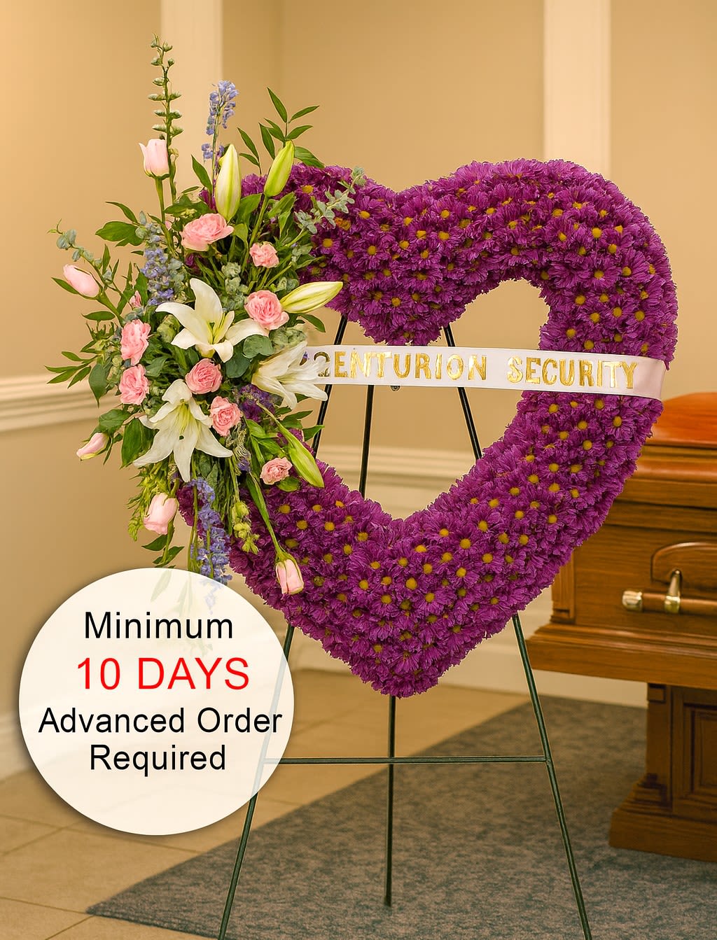 Tall purple heart-shaped funeral wreath with pink and white flowers on a stand