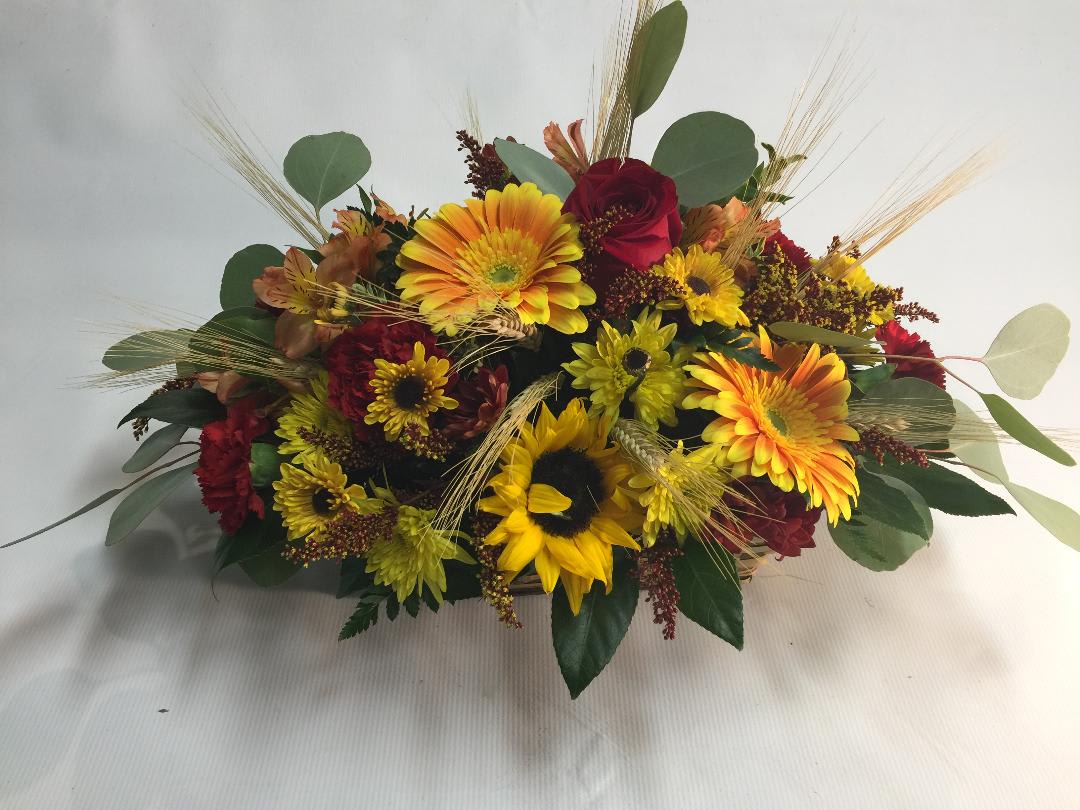 AUTUMNS VIBRANT BEAUTY  - Our Autumn-inspired arrangement captures fall’s unique, vibrant beauty. it’s loosely gathered for the look of fresh-picked wildflowers. Displayed inside our elegant Timeless basket, it’s a charming gift for your next autumn gathering.