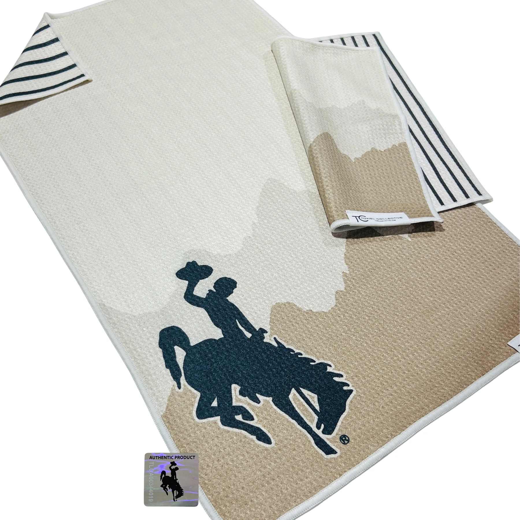 Folded beige and white blanket with a horse-and-rider graphic