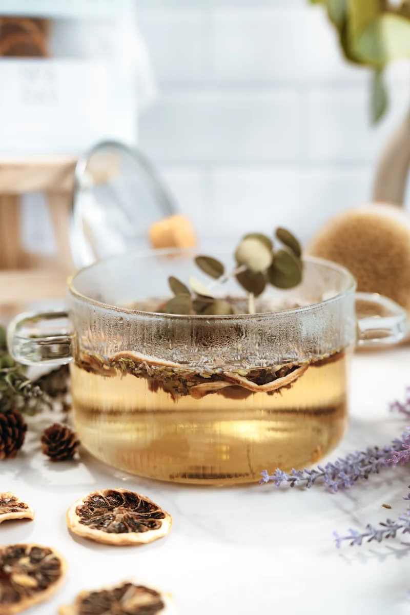 Glass mug with tea and dried citrus slices on a table