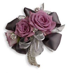 Roses And Ribbons Corsage - Lavender roses and romantic ribbons surrounded by classic rhinestones are simply spectacular.  Lavender spray roses embellished with rhinestones and ribbons.  Approximately 5" W x 5" H  Orientation: N/A 