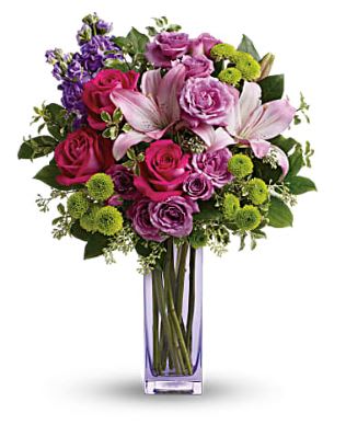 Bouquet of pink and purple flowers in a tall glass vase