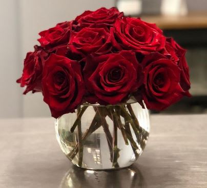 Red roses arranged in a clear glass vase