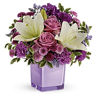 Purple and white floral arrangement in a lavender vase
