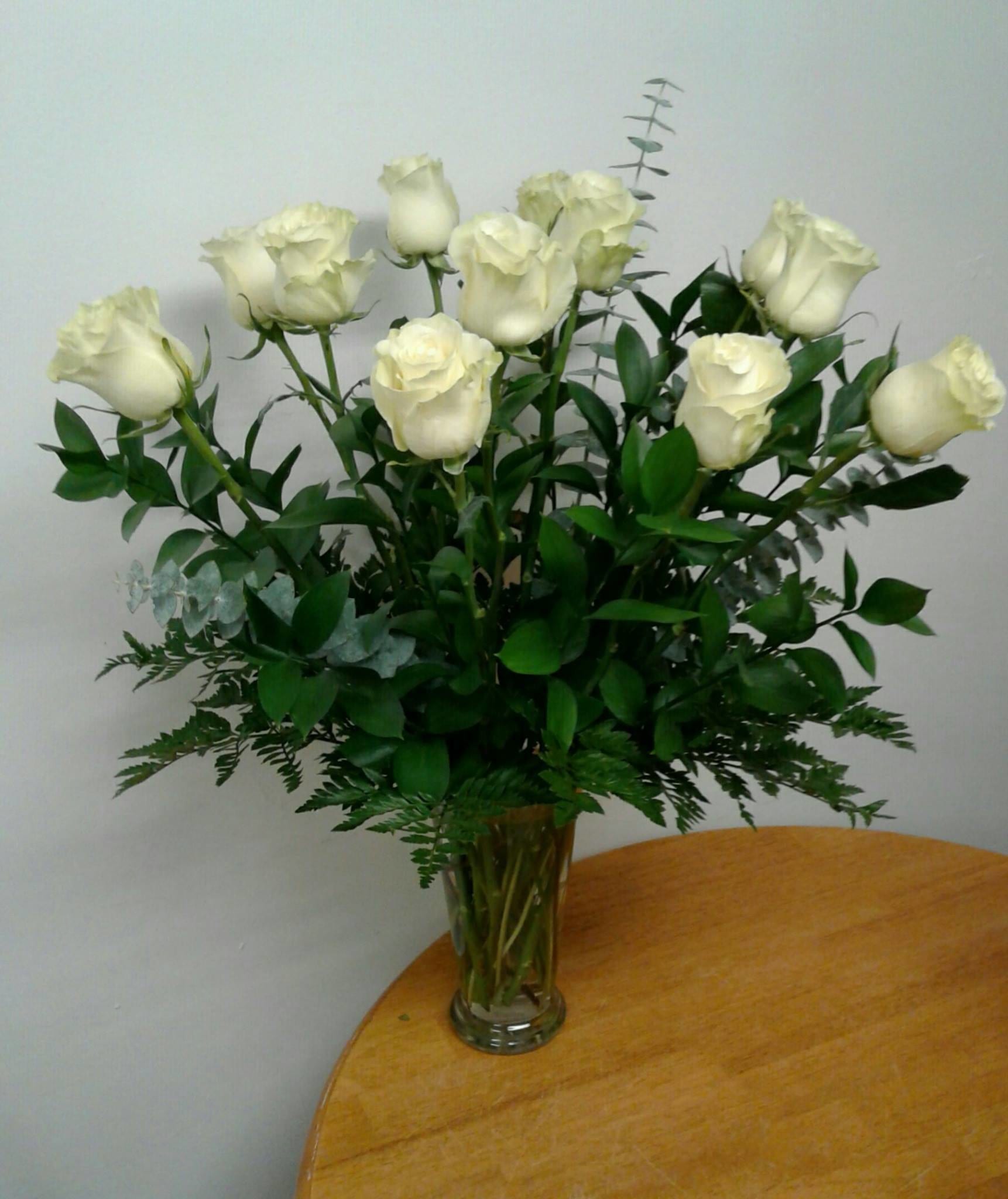 White roses arranged in a clear glass vase