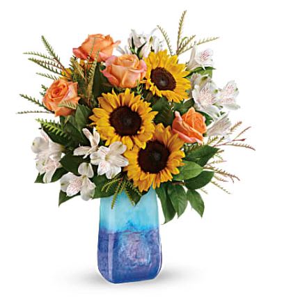 Sunflowers and peach roses in a blue glass vase
