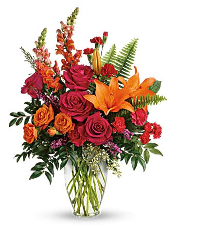 Bouquet of orange lilies and red roses in a clear glass vase