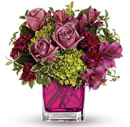 Pink and purple mixed bouquet in a magenta glass vase