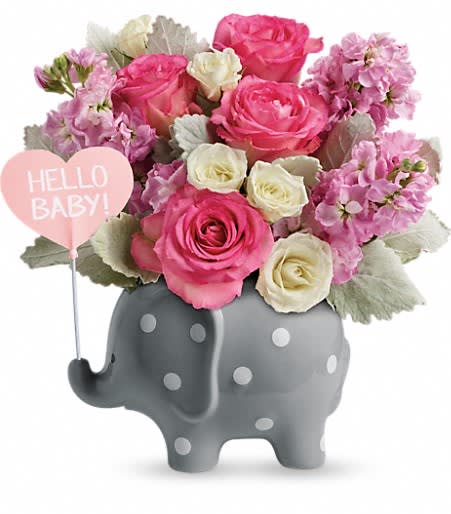 Pink and white flower arrangement in a gray elephant container with a baby sign