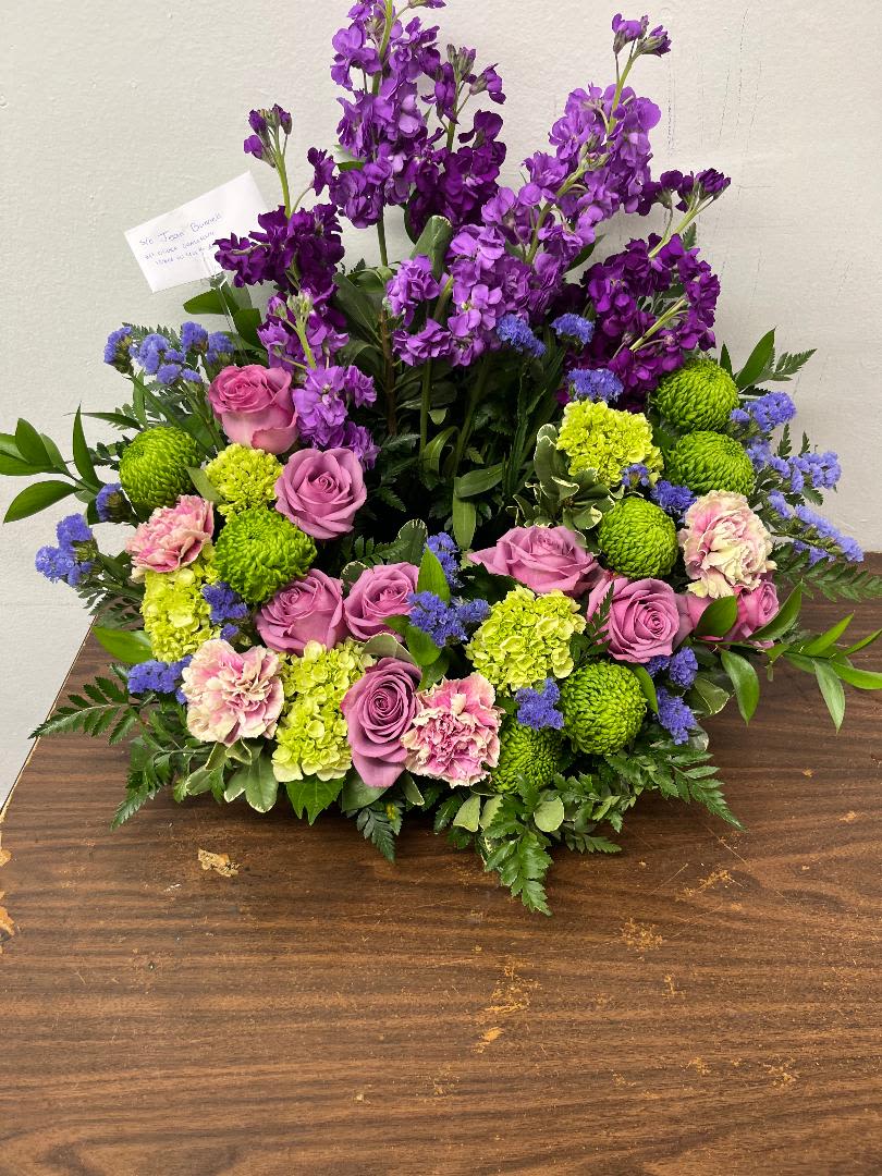 Purple and pink floral arrangement with green blooms on a table
