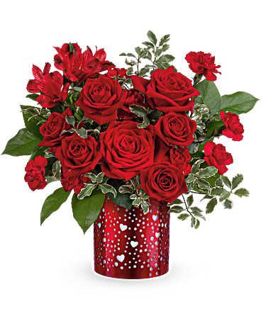 Red roses and carnations in a heart-patterned red vase